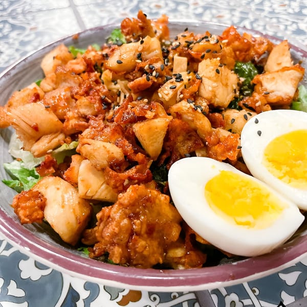 Nuri Fusion Street Kitchen's spicy chicken and kimchi salad with hard-boiled eggs and sesame seeds.